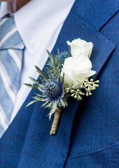 a man in a blue suit with a boutonniere on his lapel