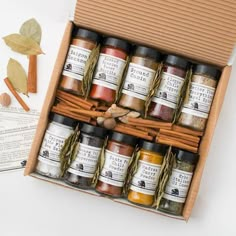 an open box filled with spices next to some cards and cinnamons on the table