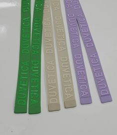 four green, white and purple lanyards with words on them