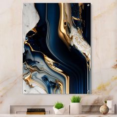 an abstract painting with gold, blue and white colors on the wall in a living room