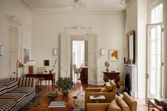 a living room filled with furniture and a fire place next to a doorway on the wall