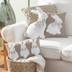 two bunny pillows sitting on top of a white couch