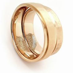 two gold wedding rings with fingerprints on each one, set against a white background