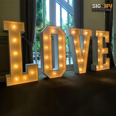 lighted letters spelling love in front of a window