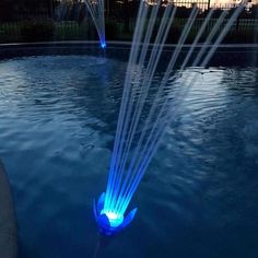 a fountain with water spewing out of it in the middle of a pool