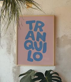 a pink and blue poster hanging on the wall next to a green potted plant