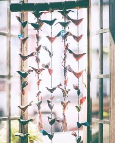 an open window with many birds hanging from it's sides and on the outside