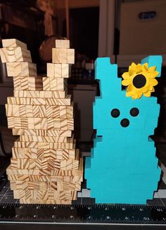 two pieces of wood that have been made to look like animals with sunflowers on their heads