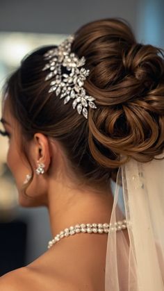 a woman wearing a bridal hair comb with pearls on her head and veil draped over her shoulder