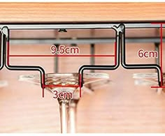 three wine glasses sitting on top of a wooden table next to each other with measurements