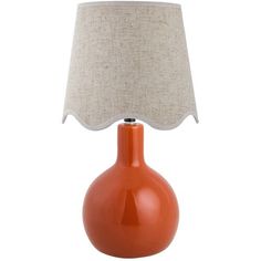 an orange table lamp with a white shade on it's base and a beige linen lampshade