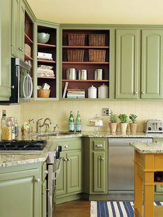 a kitchen filled with lots of green cabinets