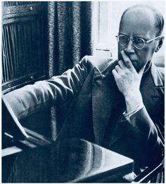 a man sitting at a table with his hand on his chin