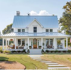 a white house with a blue roof and steps leading up to the front porch area