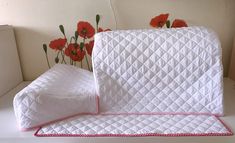 an image of a white bed with red flowers on the headboard and pillow cover