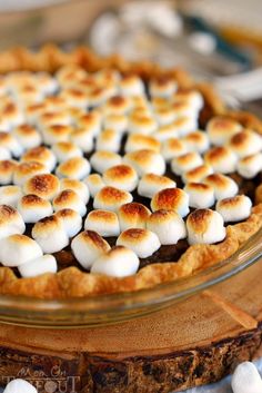 a pie topped with marshmallows on top of a wooden table