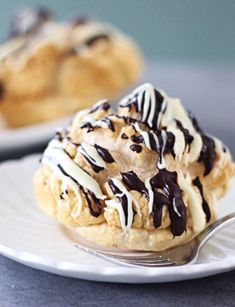 two white plates topped with pastries covered in chocolate