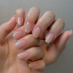 a woman's hand with some pink and white glittered nails on it,