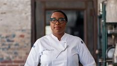 a woman wearing glasses and a chef coat