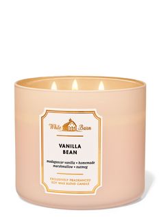 a candle that is sitting in front of a white background with an orange label on it