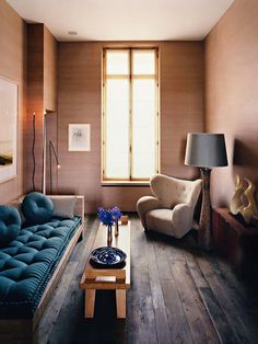 a living room filled with furniture and a lamp on top of a wooden coffee table