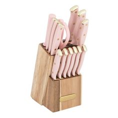 a set of pink kitchen knives in a wooden holder