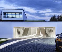 a car parked in front of a white building with stairs leading up to it's entrance