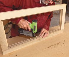 a man using a power drill to attach a piece of wood