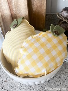 two decorative pumpkins sitting in a bowl on the counter