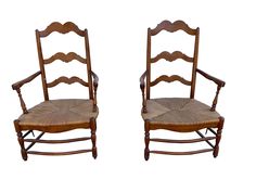 two wooden chairs sitting side by side against a white background