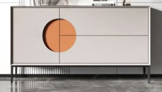 a white cabinet with an orange circle on the front and side panels, sitting in a room