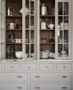 a white china cabinet filled with lots of dishes