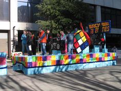 some people are standing on a colorful float