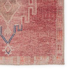 an old red rug with blue and white designs on the bottom, in front of a white background