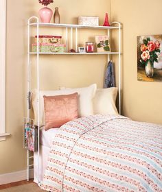 a bedroom with a bed, shelves and pictures on the wall above it that have flowers in vases