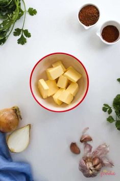 the ingredients to make this dish include cheese, onions and garlic on a white surface