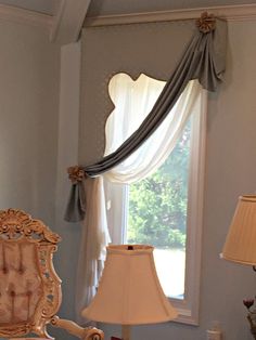 a bed room with a neatly made bed next to a lamp and a large window