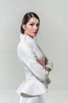 a woman is posing for a photo wearing a white jacket and skirt with her arms crossed