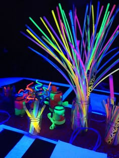 there are many different colored sticks in vases on the table and one is lit up