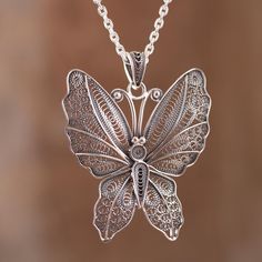 The wings of a beautiful, nocturnal butterfly are captured in sterling silver, featuring marvelous handcrafted filigree openwork. Paola Siza of Peru, who designs the necklace, works in the hope of opening a school for young artisans. Filigree Pendant Necklace, Bridesmaid Pearls, Filigree Necklaces, Filigree Jewelry, Goth Jewelry, Silver Jewelry Design, Roman Glass, Filigree Pendant, Filigree Earrings