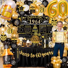 a man standing in front of a table covered with balloons and confettis