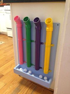 four different colored toothbrushes are in a holder on the wall next to a door