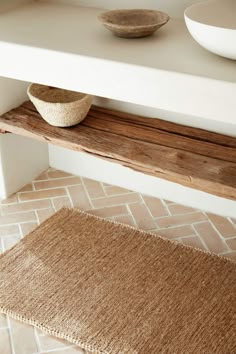 a bowl is sitting on top of a wooden shelf next to a white countertop