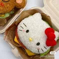 there is a hello kitty sandwich in the box on the table next to a teddy bear