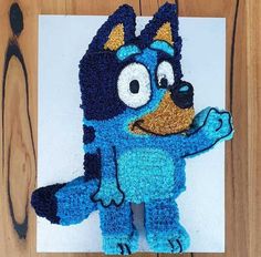 a crocheted blue and black stuffed animal on top of a piece of paper