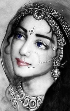 a black and white photo of a woman with blue eyes wearing an elaborate head piece