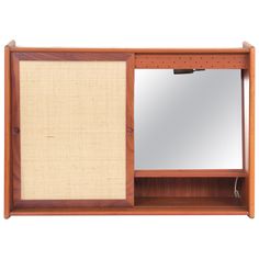 a wooden cabinet with a mirror and shelf on it's side, against a white background