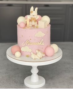 a pink cake with white and gold decorations