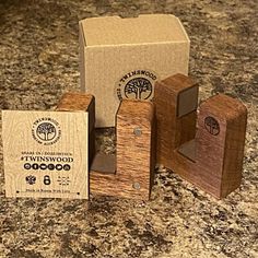 two wooden blocks sitting on top of a counter next to a box and some other items