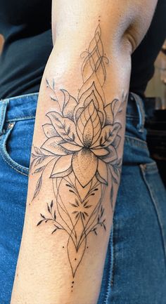 a woman's arm with a tattoo on it and a flower in the middle